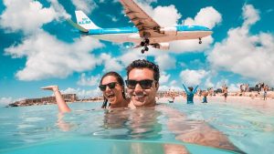 Tourists experiencing the world-famous sight of plane landing over Maho beach on St Maarten / St Martin