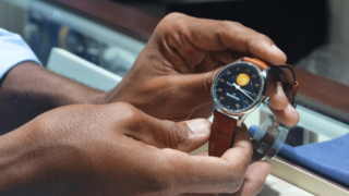 man showing a watch to customer in shop