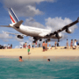 A plane flying over Maho Beach 