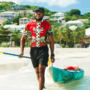 A man walking on the beach with a kayak