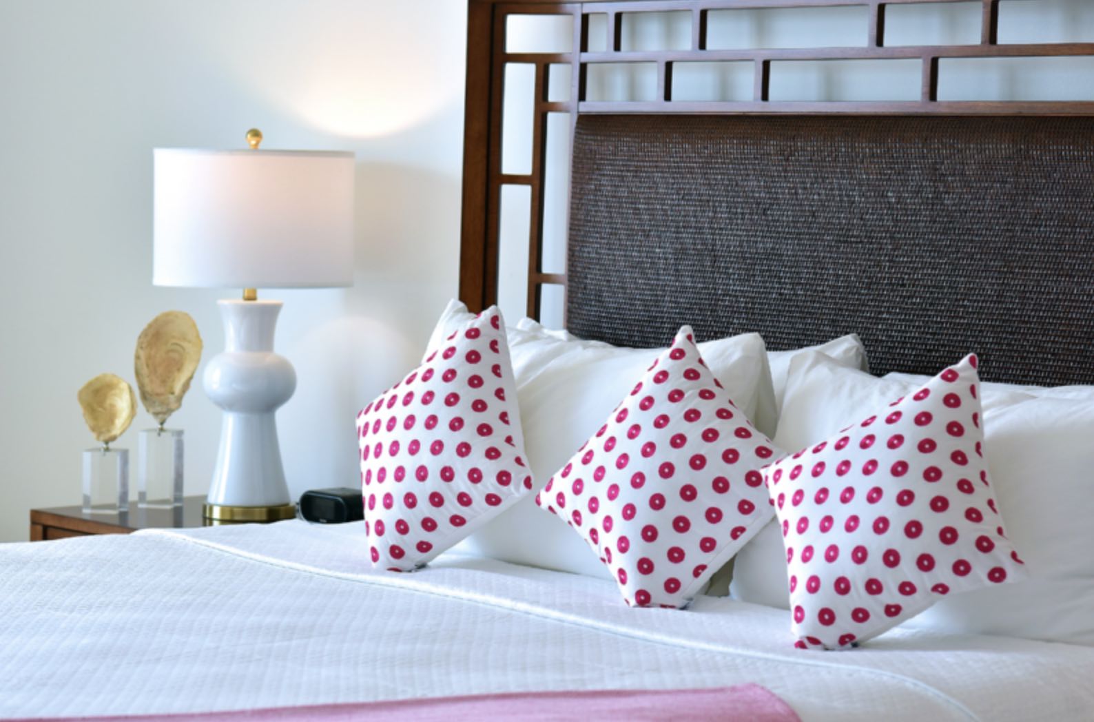 The tasteful decor at the Coral Beach Club showing bed with pink dotted cushions